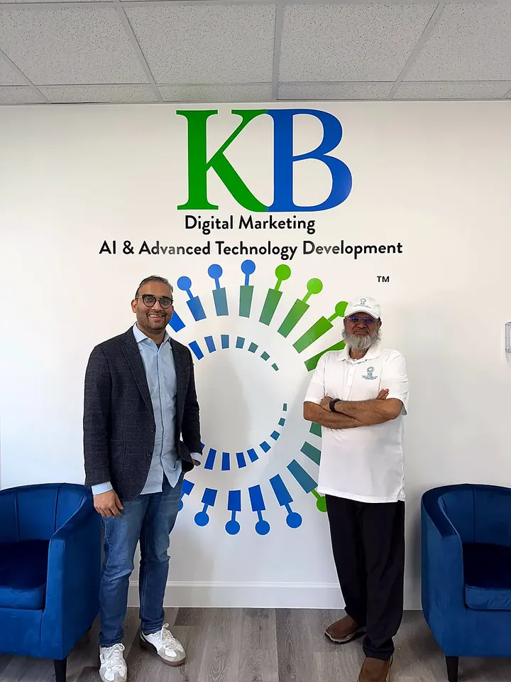 Clients and the K Business Solutions Inc. team in front of the KB logo wall at our Cypress, Texas office