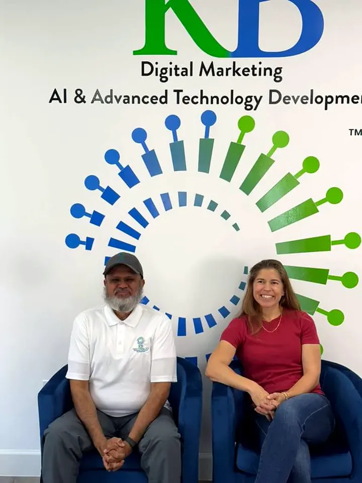 Clients and the K Business Solutions Inc. team in front of the KB logo wall at our Cypress, Texas office