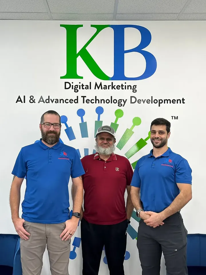 Clients and the K Business Solutions Inc. team in front of the KB logo wall at our Cypress, Texas office