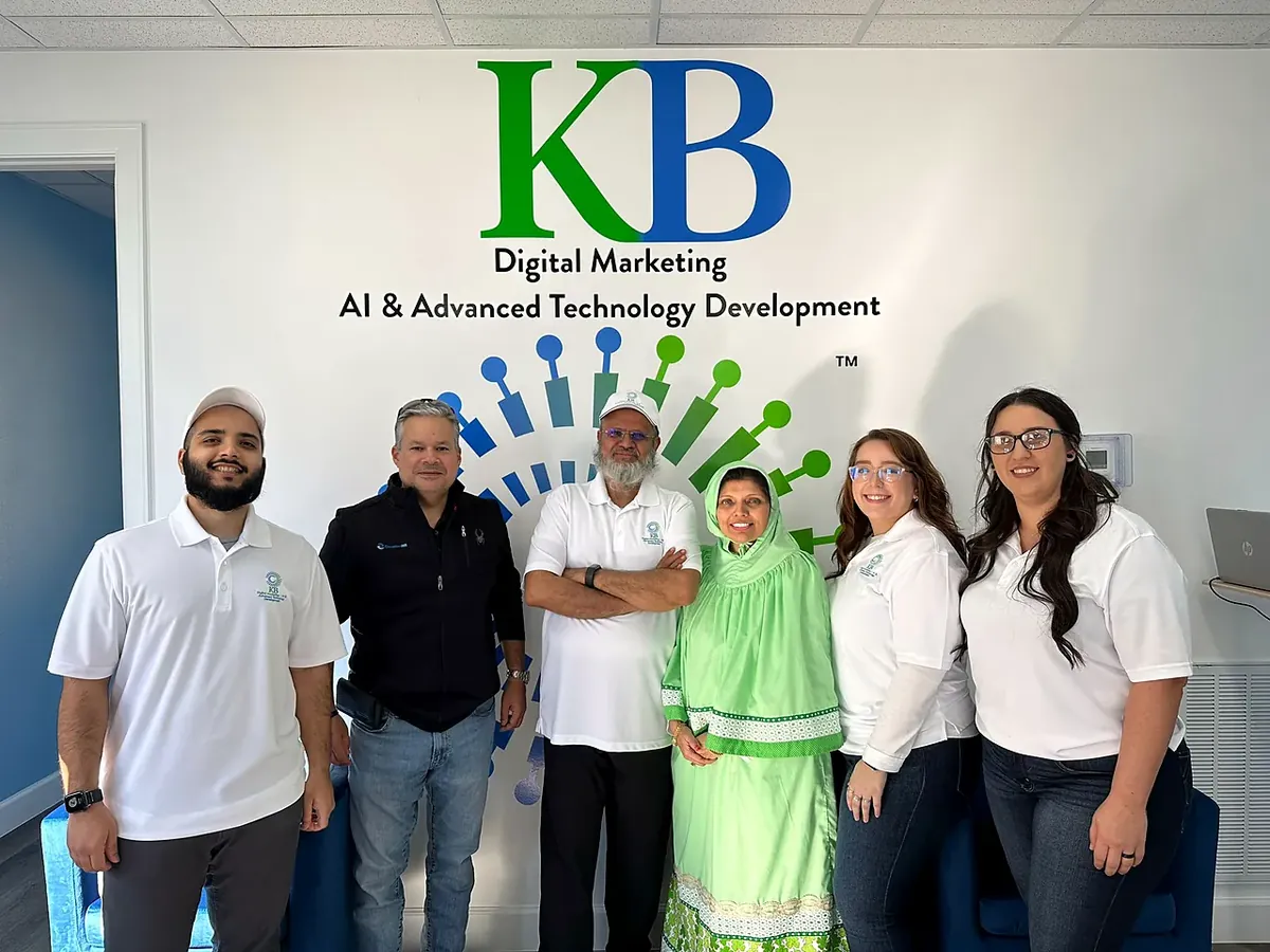 Clients and the K Business Solutions Inc. team in front of the KB logo wall at our Cypress, Texas office