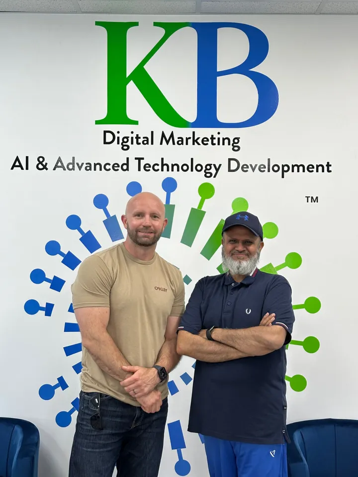 Amir Rangwala with a client in front of the K Business Solutions Inc. wall
