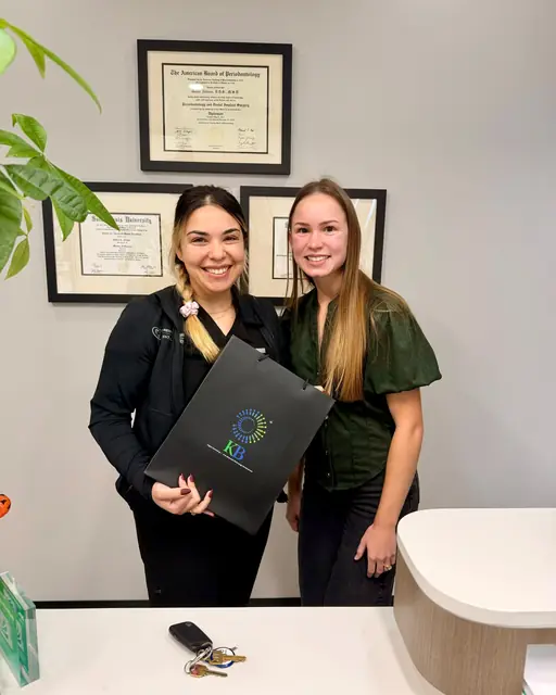 Our team with a periodontics practice client at their front desk